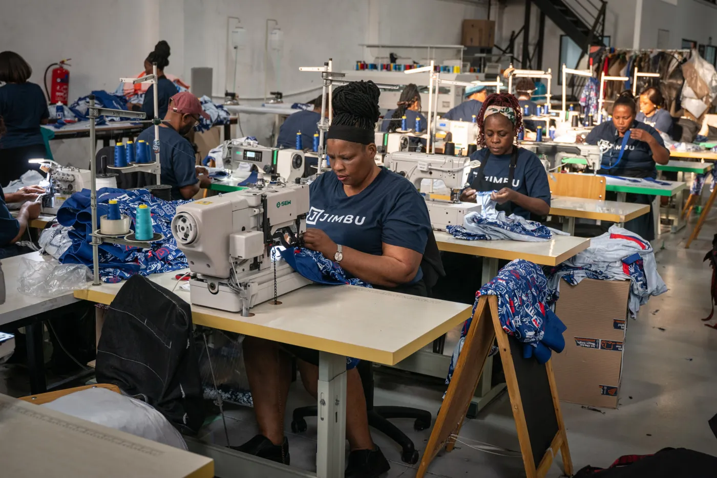 Machinists sewing garments on the floor of the JIMBU in-house CMT factory