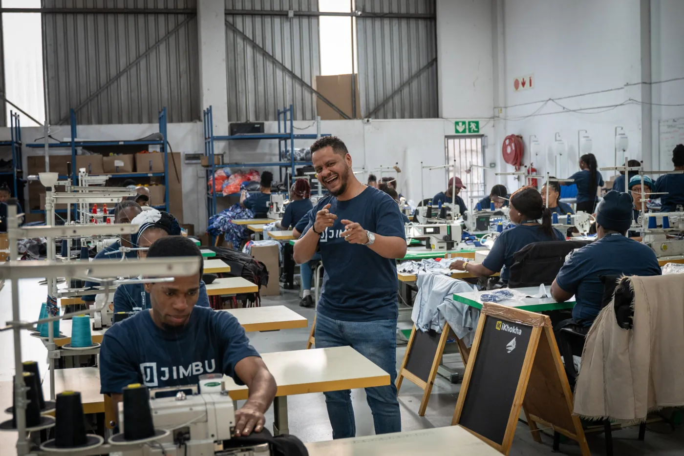 Daz, head of the JIMBU CMT factory, on the factory floor with the sewing team