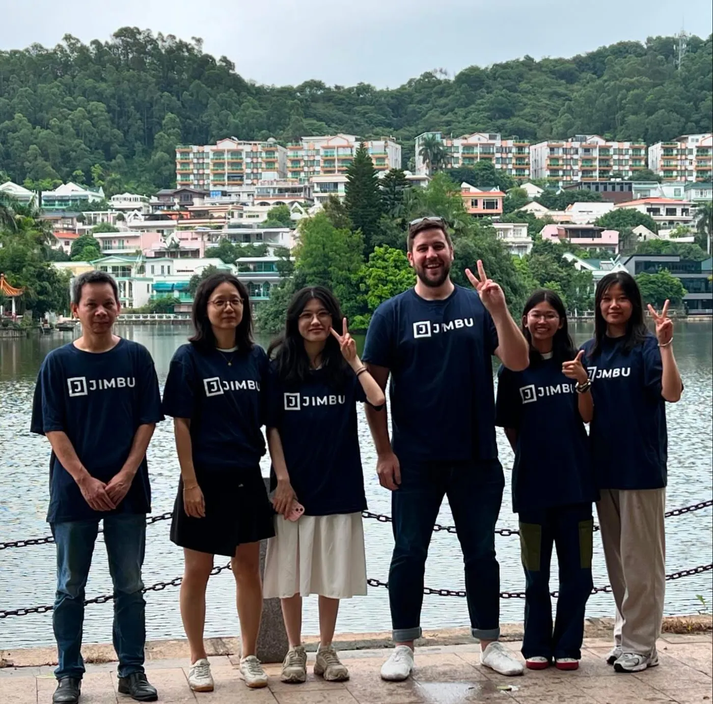 JIMBU China team in branded JIMBU T-shirts beside a lake